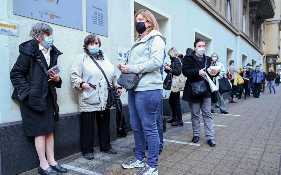 People wait for their first dose of the Covid-19 vaccine developed by China's Sinopharm company, at a vaccination center of a seniors club in Budapest - ATTILA KISBENEDEK /AFP