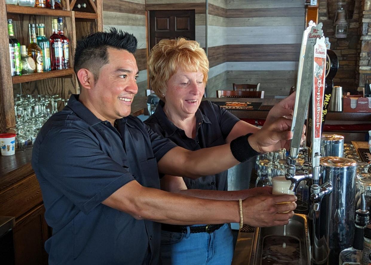 H2-B worker Francisco (whose last name has been withheld by request) and Janet Boyer pull a couple of tap beers at Mt. Rushmore Brewing Company ahead of the tourist season in Custer.