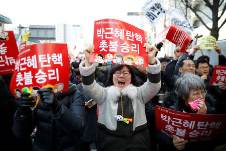 People celebrate after hearing that President Park Geun-hye's impeachment was accepted in front of the Constitutional Court in Seoul, South Korea, March 10, 2017. REUTERS/Kim Hong-Ji