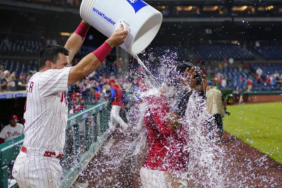 Philadelphia Phillies' Jean Segura, right, is doused by Kyle Schwarber after hitting a game-winning RBI-single during the ninth inning of a baseball game against the Miami Marlins, Tuesday, Sept. 6, 2022, in Philadelphia. (AP Photo/Matt Slocum)