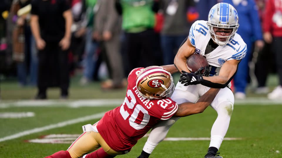 Detroit Lions wide receiver Amon-Ra St. Brown is tackled by San Francisco 49ers cornerback Ambry Thomas during the first half of the NFC championship game. - David J. Phillip/AP