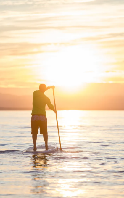 A paddleboarder on Lake Champlain at sunset.