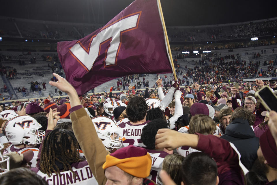 Virginia Tech players celebrate after defeating Virginia in an NCAA college football game Saturday, Nov. 25, 2023, in Charlottesville, Va. (AP Photo/Mike Caudill)