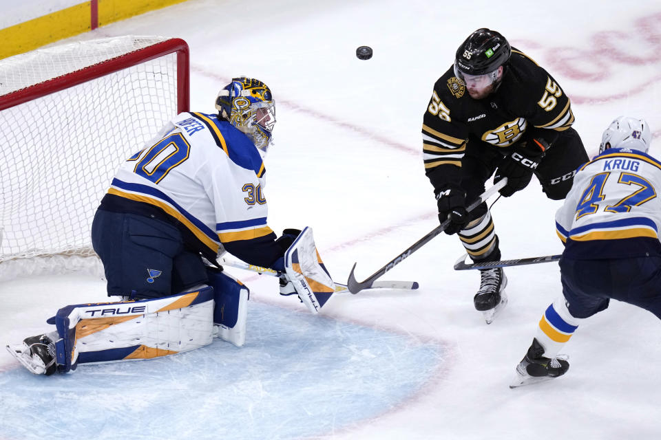 Boston Bruins right wing Justin Brazeau (55) flips the puck over St. Louis Blues goaltender Joel Hofer (30) during the second period of an NHL hockey game, Monday, March 11, 2024, in Boston. Brazeau was at first credited with a goal on the play but officials reversed the score after offsides by the Bruins was confirmed on video replay. (AP Photo/Charles Krupa)