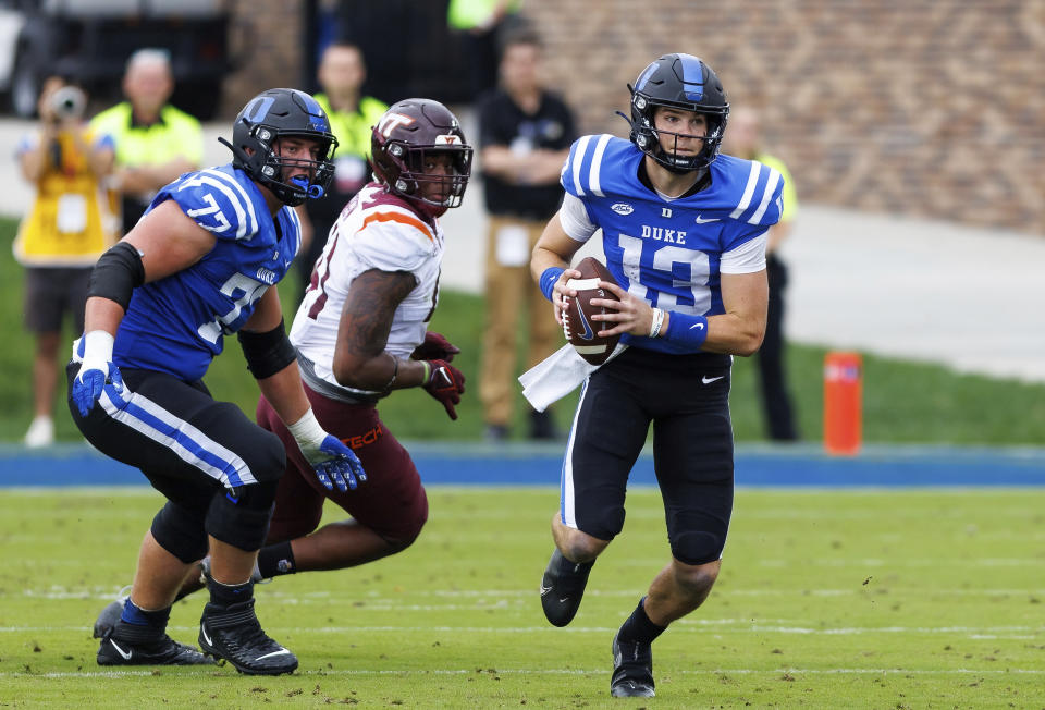 Duke's Riley Leonard (13) carries the ball ahead of Justin Pickett (77) and Virginia Tech's Jaylen Griffin (41) during the first half of an NCAA college football game in Durham, N.C., Saturday, Nov. 12, 2022. (AP Photo/Ben McKeown)