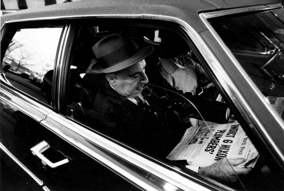<p>Former U.S. Attorney General John N. Mitchell reads newspaper front page headline, “Indict 6 Nixon Plumbers,” in his car as he leaves U.S. District Court in New York City on March 7, 1973. Mitchell was on trial for criminal conspiracy in the Watergate scandal. (Photo: Ray Stubblebine/AP) </p>