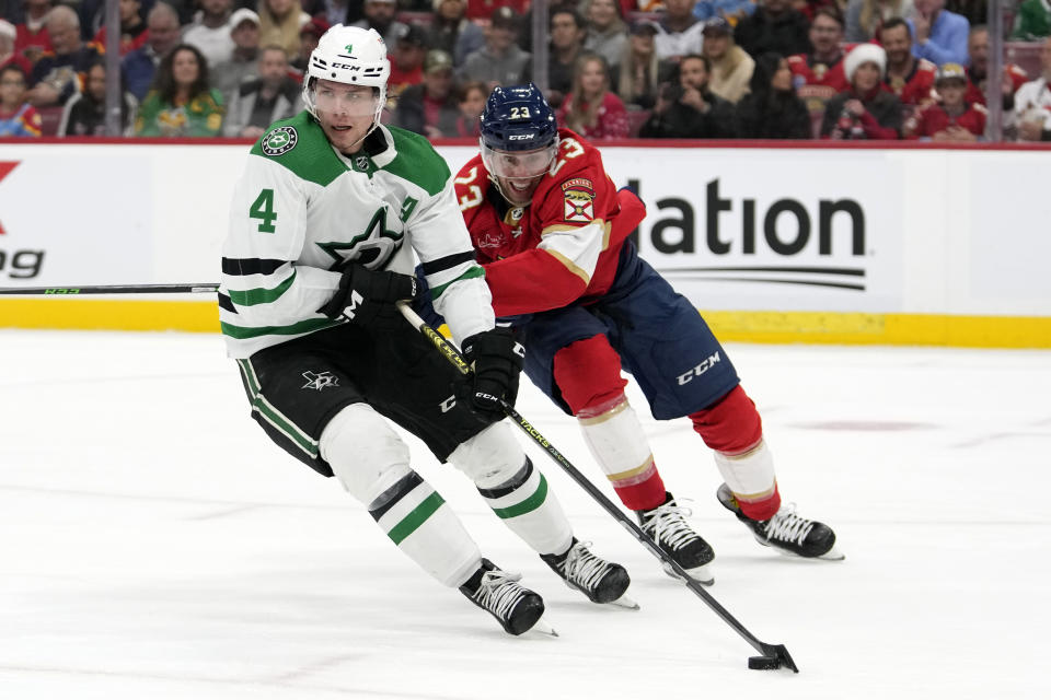 Dallas Stars defenseman Miro Heiskanen (4) skates with the puck as Florida Panthers center Carter Verhaeghe (23) defends during the second period of an NHL hockey game, Wednesday, Dec. 6, 2023, in Sunrise, Fla. (AP Photo/Lynne Sladky)
