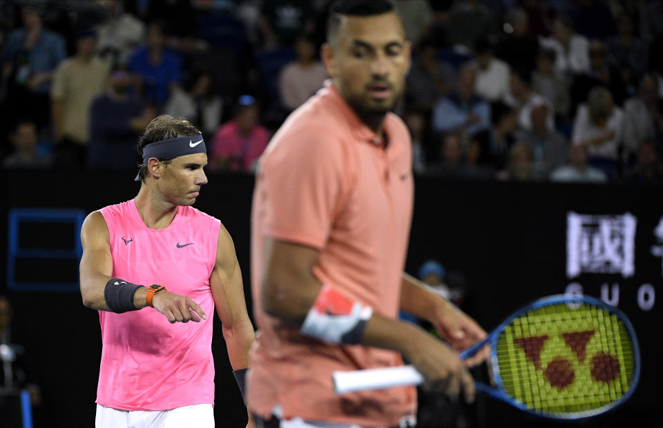 Spain's Rafael Nadal, left, walks to his chair during break in his fourth round match against Australia's Nick Kyrgios at the Australian Open tennis championship in Melbourne, Australia, Monday, Jan. 27, 2020. (AP Photo/Andy Brownbill)