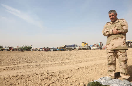 A member of Popular Mobilization Forces (PMF) fighter pray during a battle with Islamic State militants in west of Mosul, Iraq November 14, 2016. REUTERS/Stringer