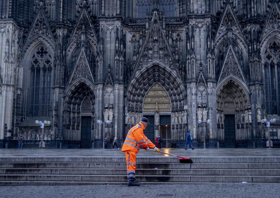 A public employee cleans the square in front of the Cathedral in Cologne, Germany, Wednesday, Nov. 30, 2022. An unprecedented crisis of confidence is shaking the Archdiocese of Cologne. Catholic believers have protested their deeply divisive bishop and are leaving in droves over allegations that he may have covered up clergy sexual abuse reports. (AP Photo/Michael Probst)