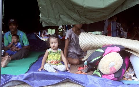 A family rest in a tent at an evacuee camp in Klungkung - Credit: AP Photo/Firdia Lisnawati