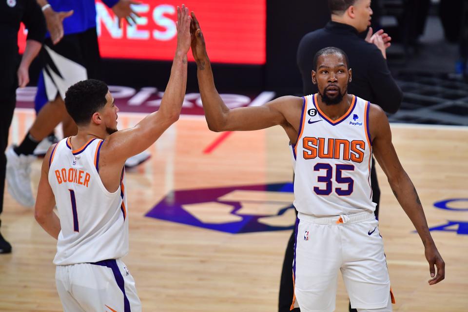 Le gardien des Phoenix Suns Devin Booker (1) réagit après que l'attaquant Kevin Durant (35) ait marqué un panier à trois points contre les Clippers de Los Angeles au cours de la seconde mi-temps du quatrième match des éliminatoires de la NBA 2023 à Crypto.com Arena le 22 avril 2023.