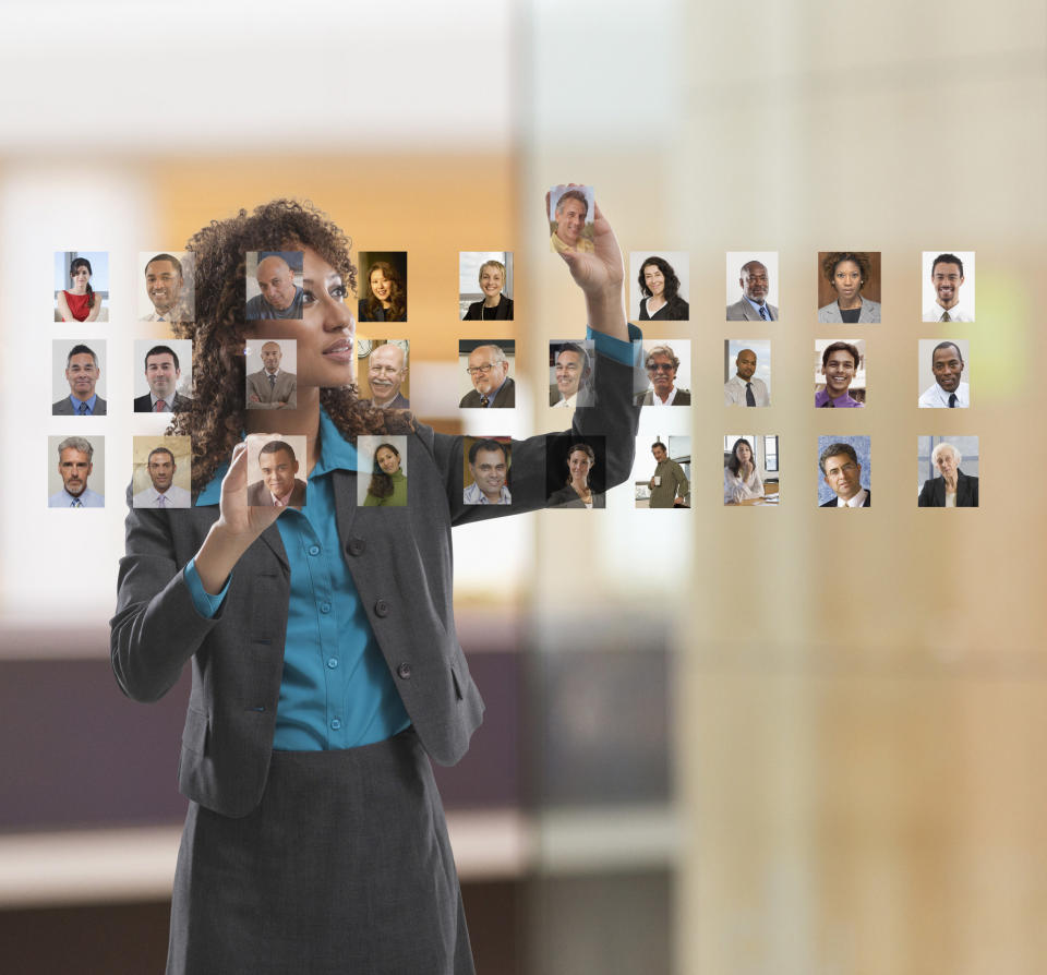 a woman putting photos on a glass wall