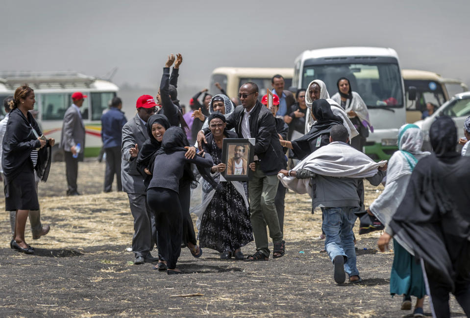 FILE - In this Thursday March 14, 2019 file photo, Ethiopian relatives of crash victims mourn at the scene where the Ethiopian Airlines jet crashed near Bishoftu, in Ethiopia, just after taking off from Addis Ababa on March 10, killing all 157 on board. A preliminary report finds that the crew of the Ethiopian Airlines jet that crashed last month performed all the procedures recommended by Boeing but could not control the plane. (AP Photo/Mulugeta Ayene, File)