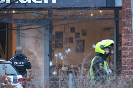 Police presence is seen next to damaged glass at the site of a shooting in Copenhagen February 14, 2015. REUTERS/Mathias OEgendal/Scanpix Denmark
