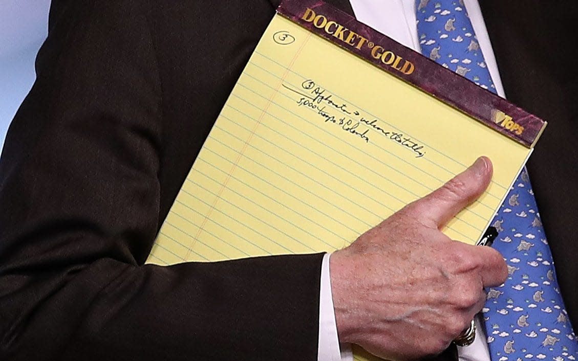 John Bolton on Monday carrying a notepad with the message: 