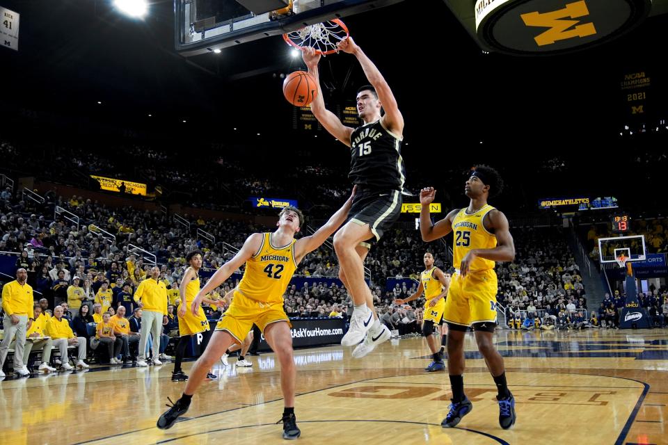 Purdue center Zach Edey dunks past Michigan's Will Tschetter, left, and Jace Howard in the first half at Crisler Center in Ann Arbor on Sunday, Feb. 25, 2024.