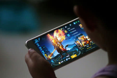 FILE PHOTO: A child plays the game "Honour of Kings" by Tencent at home in Dezhou, Shandong province, China July 2, 2017. REUTERS/Stringer/File Photo ATTENTION EDITORS - THIS IMAGE WAS PROVIDED BY A THIRD PARTY. CHINA OUT. NO COMMERCIAL OR EDITORIAL SALES IN CHINA