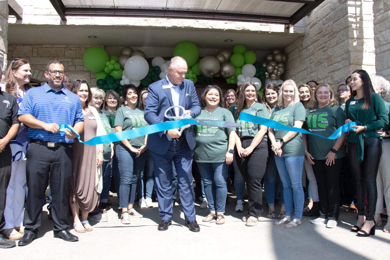 Andy Marshall, President and CEO, surrounded by bank staff and Amarillo Hispanic Chamber of Commerce members, cuts the ribbon during the FirstBank Southwest 115th anniversary celebration at its location on Georgia Street in this 2022 file photo.