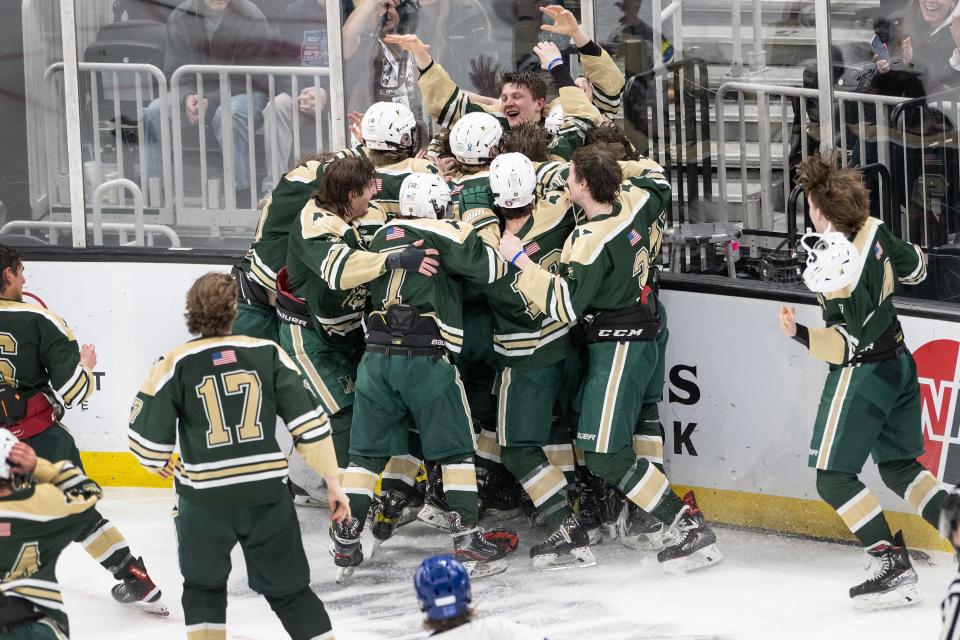 Nashoba players jump onto teammate Joe Quinn after he scored the winning goal in overtime to defeat Scituate in the Division 3 state final at TD Garden.