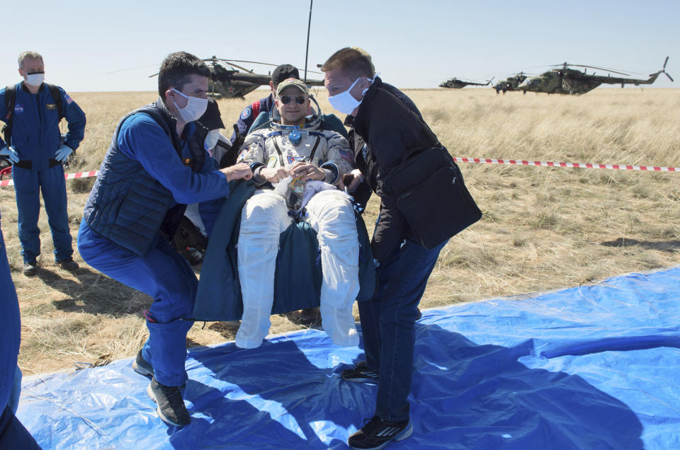 In this handout photo released by Gagarin Cosmonaut Training Centre (GCTC), Roscosmos space agency, rescue team members carry U.S. astronaut Andrew Morgan shortly after the landing of the Russian Soyuz MS-15 space capsule near Kazakh town of Dzhezkazgan, Kazakhstan, Friday, April 17, 2020. An International Space Station crew has landed safely after more than 200 days in space. The Soyuz capsule carrying NASA astronauts Andrew Morgan, Jessica Meir and Russian space agency Roscosmos' Oleg Skripochka touched down on Friday on the steppes of Kazakhstan. (Andrey Shelepin, Gagarin Cosmonaut Training Centre (GCTC), Roscosmos space agency, via AP)