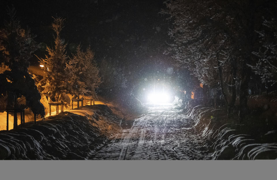 A car drives on a snow covered street at the Bavarian city Berchtesgaden, Germany, Friday, Jan 11, 2018, after Austria and southern Germany were hit by heavy snowfall. (Lino Mirgeler/dpa via AP)