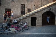 A shop owner looks through a door as people visit the Old Town of Rhodes, following the coronavirus disease (COVID-19) outbreak, on the island of Rhodes