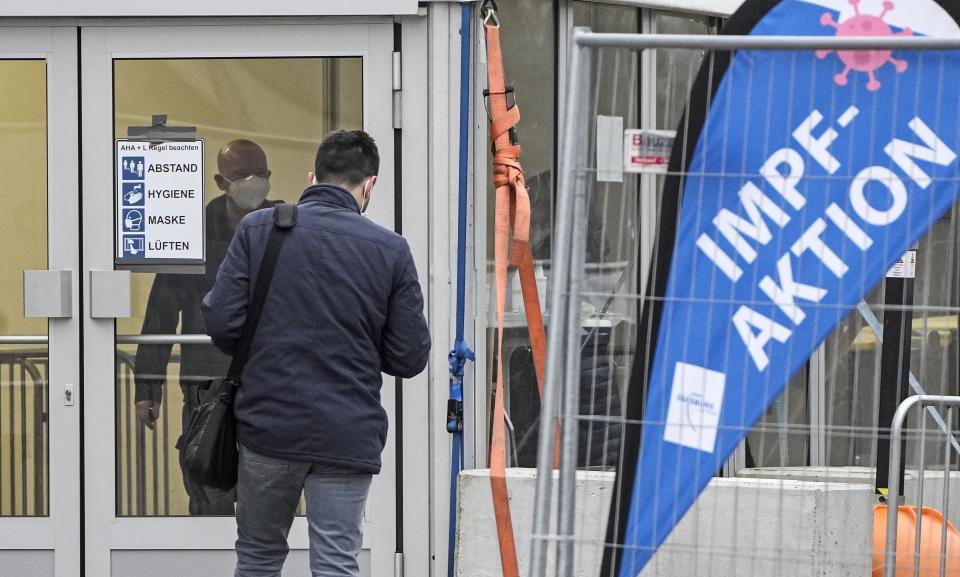 A man enters a coronavirus vaccination center in Duisburg, Germany, Tuesday, Jan. 25, 2022. Germany's parliament is set to hold its first debate Wednesday on a possible wide-ranging coronavirus vaccine mandate, with three options emerging: obligatory vaccinations for all adults or for everyone above 50, or no mandate at all. (AP Photo/Martin Meissner)