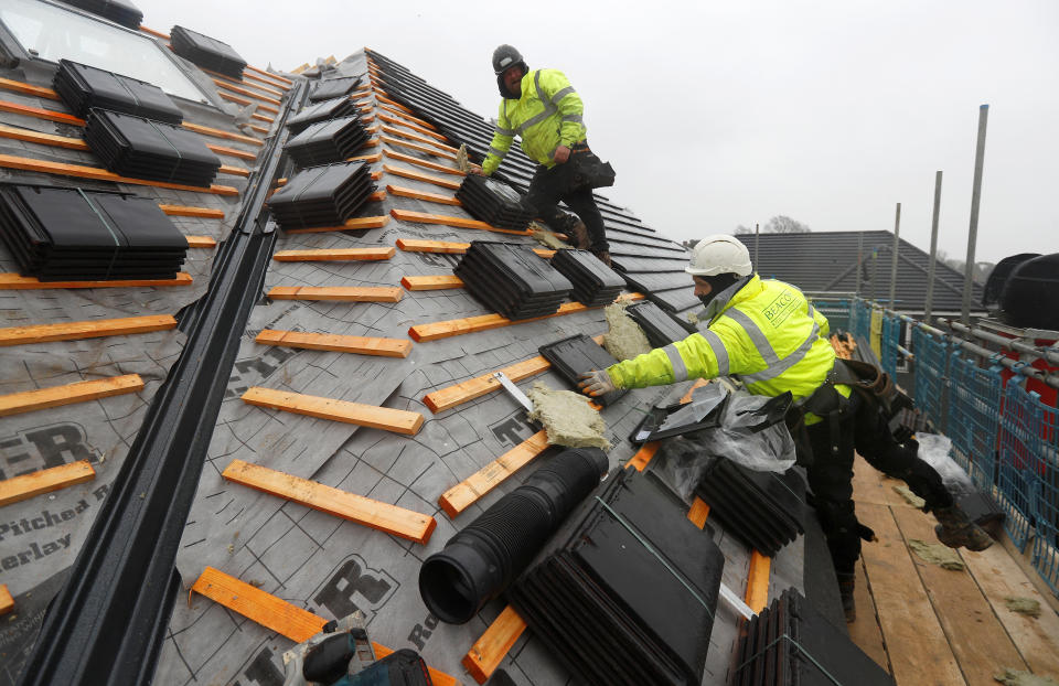 Builders work on the roof of a building at a Barratt housing development near Haywards Heath, Britain, February 20, 2020. REUTERS/Peter Nicholls