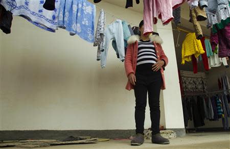 Lu Libing's wife, Mu, poses for pictures during an interview with Reuters at their home in Ganzhou, Jiangxi province March 13, 2014. REUTERS/Alex Lee