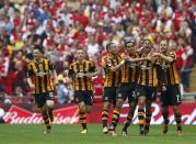 Hull City players celebrate with their team mate Curtis Davies (2R) after he scored his team's second goal against Arsenal during their FA Cup final soccer match at Wembley Stadium in London, May 17, 2014. REUTERS/Eddie Keogh (BRITAIN - Tags: SPORT SOCCER)