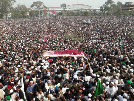 Mourners throw flower petals on an ambulance carrying the body of Mumtaz Qadri to his funeral which Pakistani broadcast media were forbidden to cover at Liaquat Bagh in Rawalpindi, Pakistan, March 1, 2016. REUTERS/Faisal Mahmood/Files