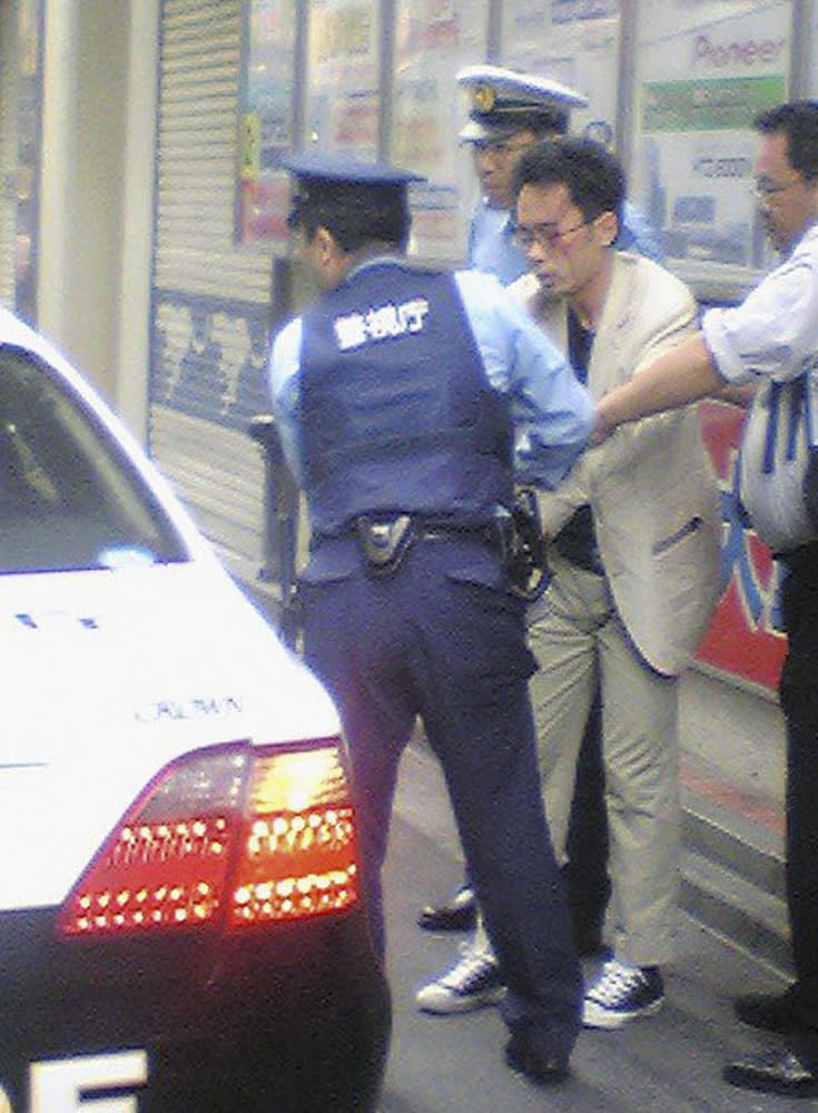 Tomohiro Kato (C), who killed seven people and wounding a dozen others, is detained by police officers at Tokyo's Akihabara district June 8, 2008 in this photo taken by an anonymous pedestrian. Kato, who said he was tired of life went on a stabbing rampage on Sunday in a crowded Tokyo shopping street, knifing passers-by in Akihabara, known for its discount electronics and maid cafes. Picture taken June 8, 2008. QUALITY FROM SOURCE  REUTERS/Kyodo (JAPAN).  JAPAN OUT. NO COMMERCIAL OR EDITORIAL SALES IN JAPAN.