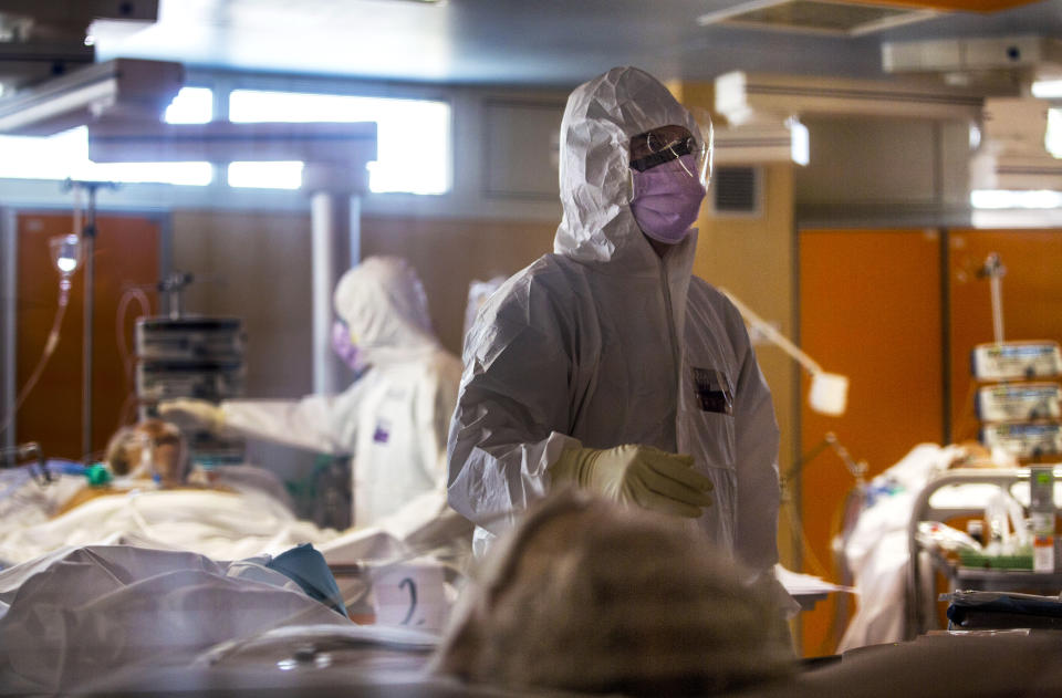 Medical staff at the intensive care unit of the Casalpalocco COVID-19 Clinic on the outskirts of Rome tend to patients, March 25, 2020. (AP Photo/Domenico Stinellis)