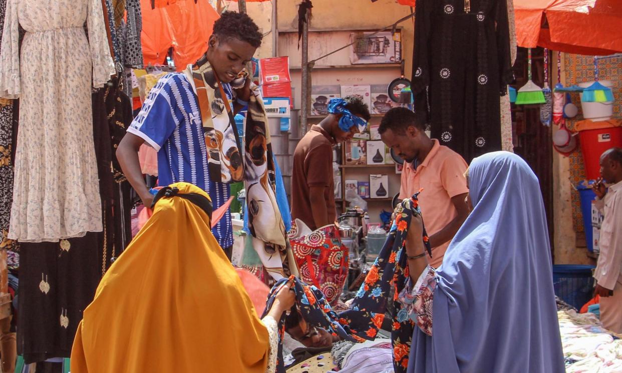 <span>Women browse fabrics in a street market in Mogadishu, December 2023.</span><span>Photograph: Said Yusuf Warsame/EPA-EFE/Shutterstock</span>