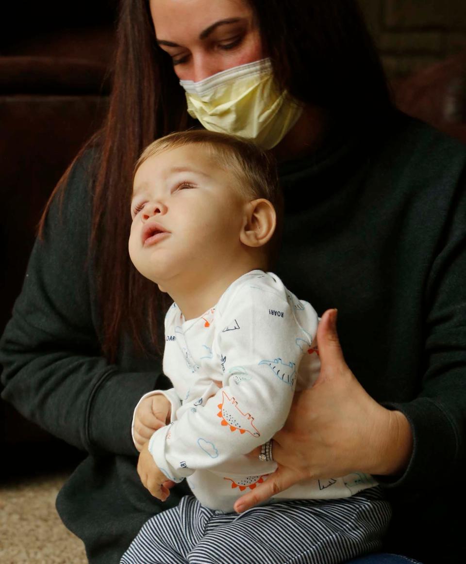 Nineteen-month-old David Detwiler sits on the lap of his mother, Carlla Detwiler, at their home in Massillon.