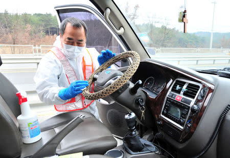 A South Korean health official disinfects a vehicle to prevent spread of bird flu in Pohang, South Korea, December 19, 2016. Choi Chang-ho/News1 via REUTERS