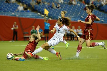 Spain defender Irene Paredes (20) dives as she tries to bock the kick of Costa Rica forward Carolina Venegas (9) as Spain defender Marta Torrejon (18) trails the play at right in the second half of a Group E soccer match in the 2015 FIFA women's World Cup at Olympic Stadium. Mandatory Credit: Eric Bolte-USA TODAY Sports