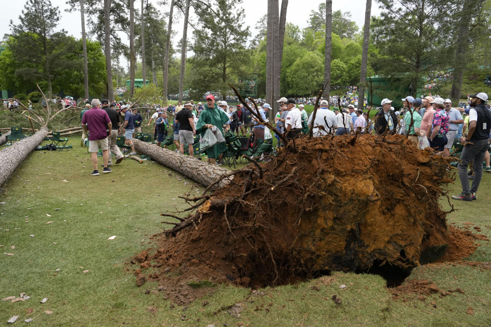 Patrons depart the course after trees blew over on the 17th hole during the second round of the Masters golf tournament at Augusta National Golf Club on Friday, April 7, 2023, in Augusta, Ga. (AP Photo/Mark Baker)