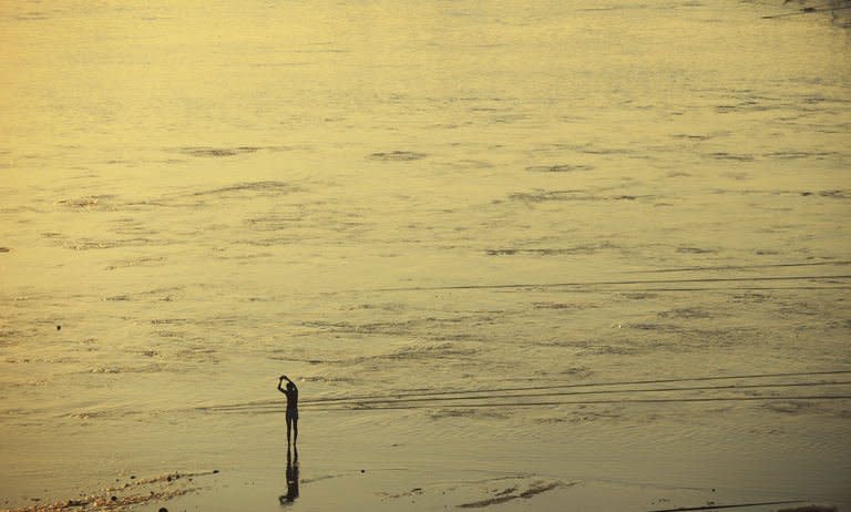 A Hindu devotee prays on the banks of the River Ganges a day before authorities expect the largest crowd during the most auspicious day of the festival, in Allahabad on February 9, 2013