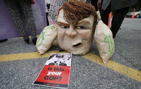 An anti-Trump mask and sign sit outside Republican National Committee (RNC) headquarters, where Republican U.S. presidential candidate Donald Trump was meeting with House Speaker Paul Ryan (R-WI) and RNC Chairman Reince Priebus in Washington, U.S., May 12, 2016. REUTERS/Jim Bourg