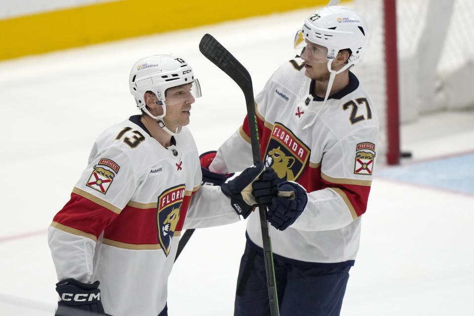 Florida Panthers center Sam Reinhart (13) celebrates with center Eetu Luostarinen (27) after scoring the winning goal in the overtime period of an NHL hockey game against the Washington Capitals, Wednesday, Nov. 8, 2023, in Washington. (AP Photo/Mark Schiefelbein)