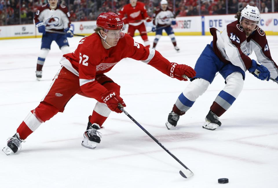 Detroit Red Wings right wing Jonatan Berggren (52) skates towards the goal against Colorado Avalanche defenseman Samuel Girard (49) during the first period of an NHL hockey game Saturday, March 18, 2023, in Detroit. (AP Photo/Duane Burleson)