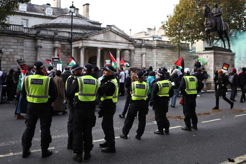 Police officers monitor protesters on Whitehall during the 'March For Palestine' in London on October 28, 2023, to call for a ceasefire in the conflict between Israel and Hamas. Thousands of civilians, both Palestinians and Israelis, have died since October 7, 2023, after Palestinian Hamas militants based in the Gaza Strip entered southern Israel in an unprecedented attack triggering a war declared by Israel on Hamas with retaliatory bombings on Gaza. (Photo by HENRY NICHOLLS / AFP) (Photo by HENRY NICHOLLS/AFP via Getty Images)