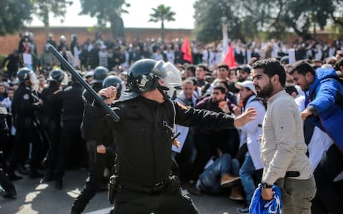 Security forces charge at protesting teachers during a demonstration in Rabat, Morocco - Credit: AP