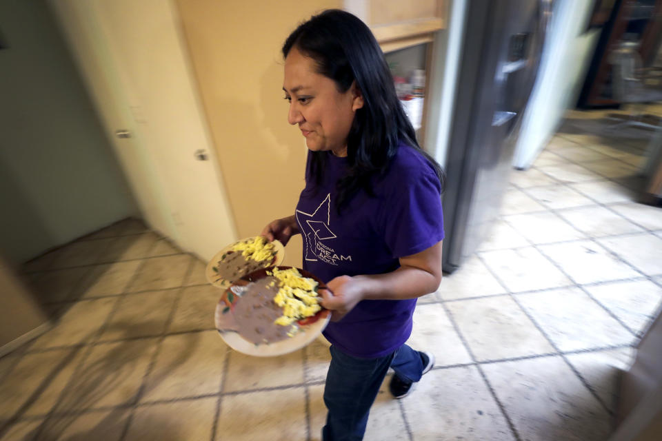 Karina Ruiz serves dinner at her home, Thursday, Nov. 7, 2019 in Glendale, Ariz. Karina is in a program dating back to the Obama administration that allows immigrants brought here as children to work and protects them from deportation. The U.S. Supreme Court will hear arguments Tuesday, Nov. 12, about President Donald Trump’s attempt to end the program, and the stakes are particularly high for the older generation of people enrolled in Deferred Action for Childhood Arrivals, known as DACA. (AP Photo/Matt York)