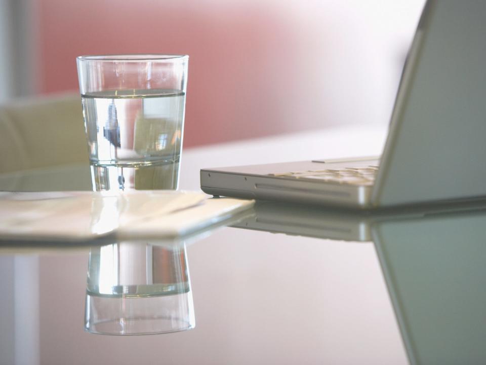 Glass of water next to computer