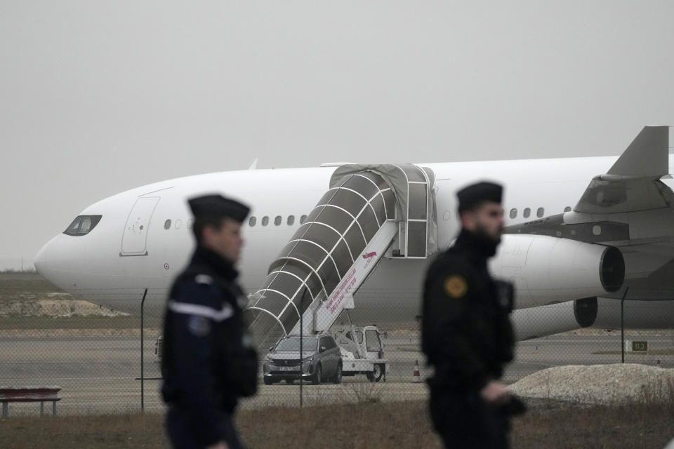 Gendarmes patrol by the plane grounded by police based that it could be carrying trafficking victims, at the Vary airport , Monday, Dec. 25, 2023 in Vatry, eastern France. A charter plane carrying 303 Indians to Nicaragua was authorized Sunday to leave a French airport where it has been grounded for four days for a human trafficking investigation. A lawyer for the airline said the plane is taking many of the stranded passengers back to India on Monday. (AP Photo/Christophe Ena)