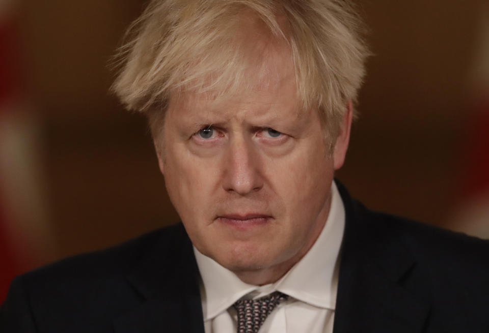 Britain's Prime Minister Boris Johnson listens to a question from the media during a news conference on the ongoing situation with the coronavirus pandemic, inside 10 Downing Street in London, Wednesday, Dec. 16, 2020. (AP Photo/Matt Dunham, Pool)