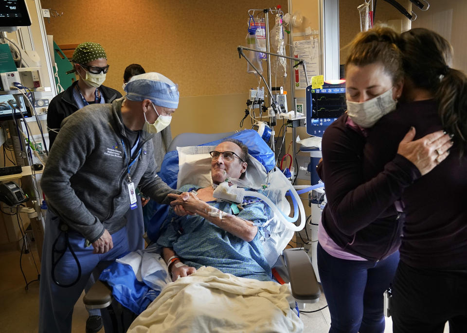 Dr. Mark Sprenkle, left, shakes hands with John Grubb as Grubb's wife Kelly, second from right, says goodbye to other HCMC caregivers before Grubb was discharged from HCMC Monday, May 3, 2021 in Minneapolis. Grubb, of St. Michael, was discharged from HCMC after 81 days on the ECMO heart-lung bypass machine. ECMO has been the treatment of last resort in COVID-19 care, saving 50% of people when used globally, but has been a critical tool when doctors run out of options for severely ill patients. (David Joles/Star Tribune via AP)